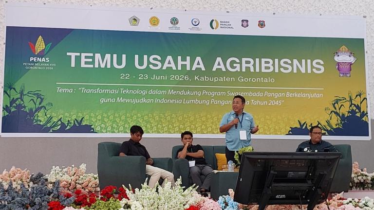 Spanduk “Temu Usaha Agribisnis” di panggung, tiga pria duduk di depan dekorasi bunga merah-putih