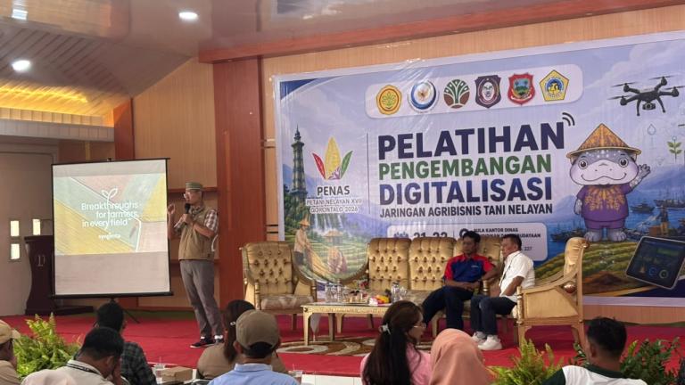 Peserta pelatihan digitalisasi duduk menghadap panggung dan layar proyektor di aula