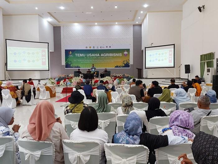 Peserta duduk di aula, menatap panggung dan layar presentasi saat seminar berlangsung.