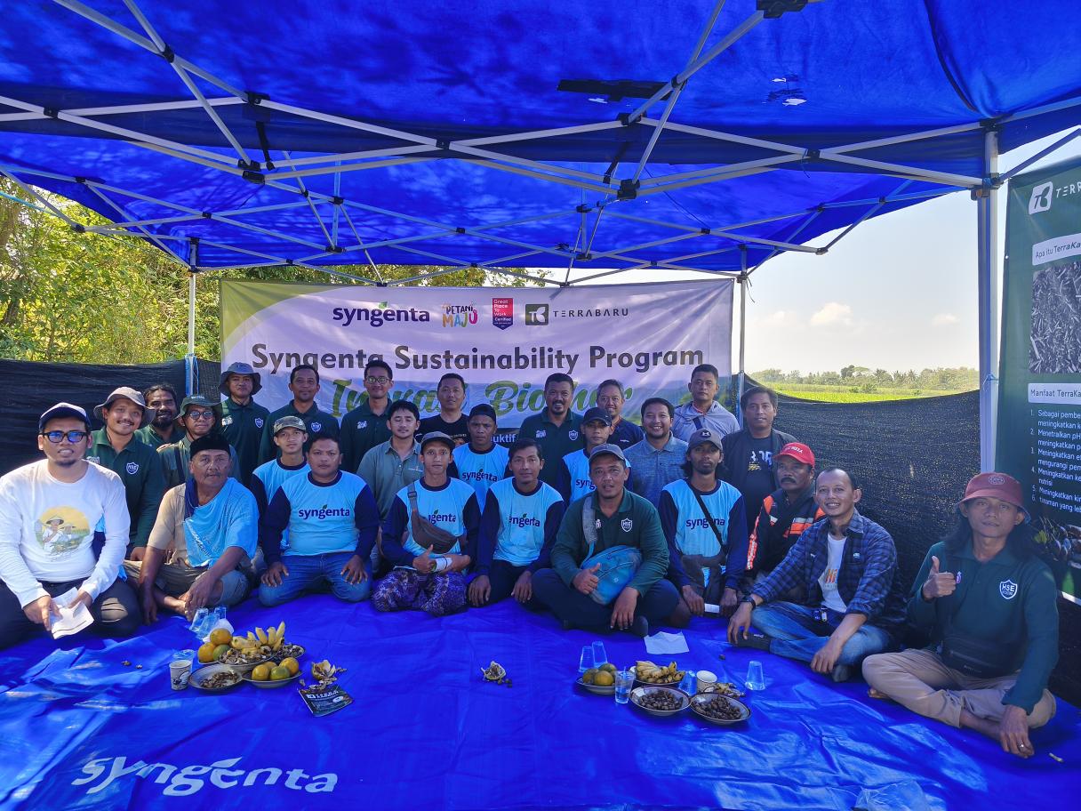 Foto kelompok peserta acara “Sustainability Program” duduk di bawah tenda biru.